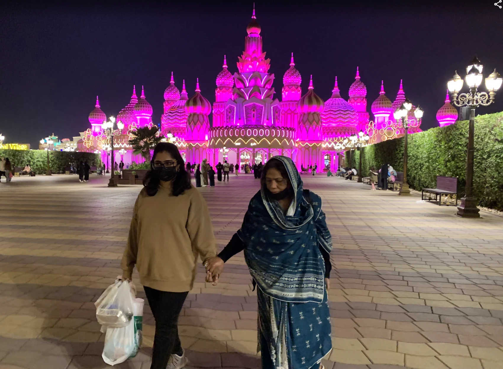 Aysha walking hand in hand with the woman who welcomed her